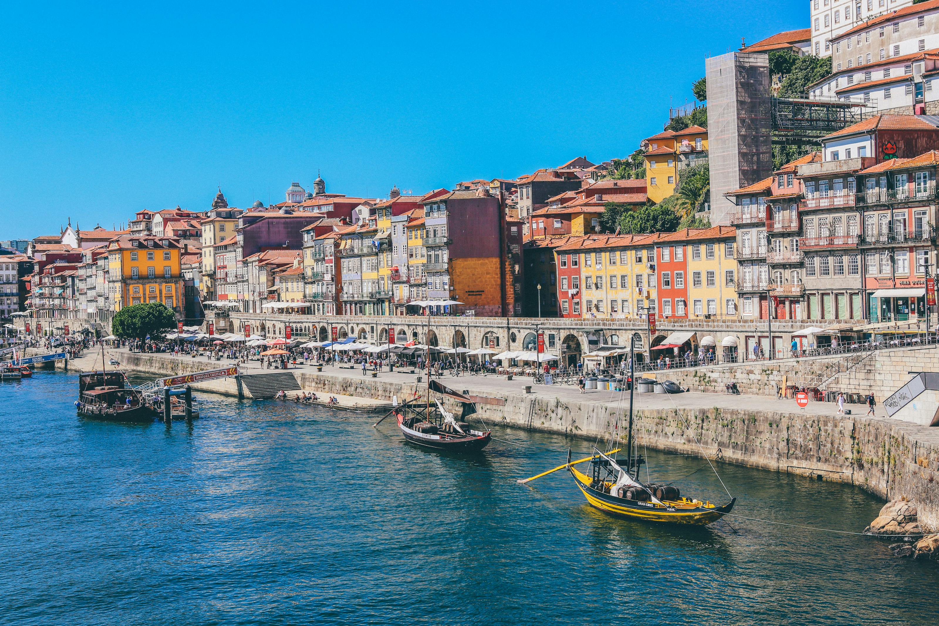 Rabelo boats on the Douro below the tiled riverfront houses of Porto